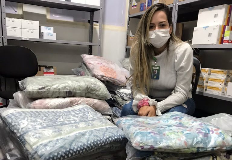 Talita Monteiro, assistente administrativa do HEF com alguns kits para entrega